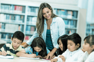 maestra con niños sentados en una mesa