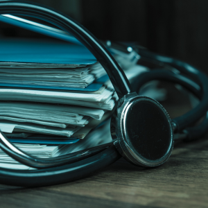 pila de expedientes con un estetoscopio encima de ellos