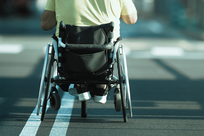 persona con discapacidad motora transitando en la vía pública en silla de ruedas
